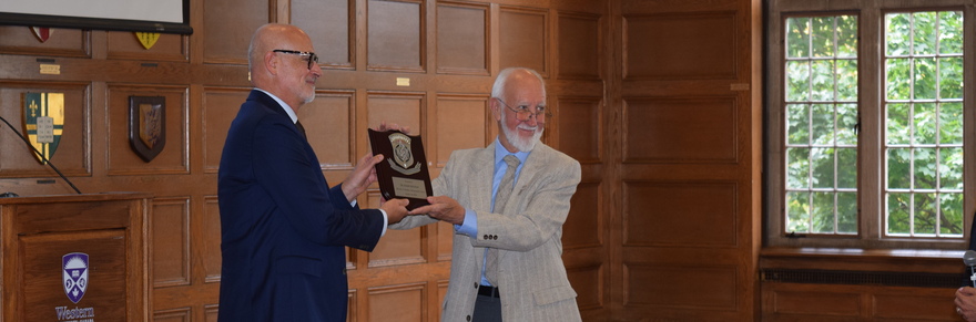 Image: Dr. Hamilton presenting Dr. Benzian the Research Day plaque 